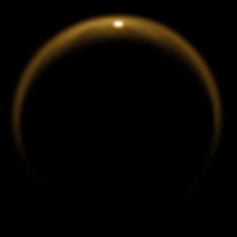 Essa imagem mostra o primeiro raio de luz solar refletido em lago na lua de Saturno, Titã.