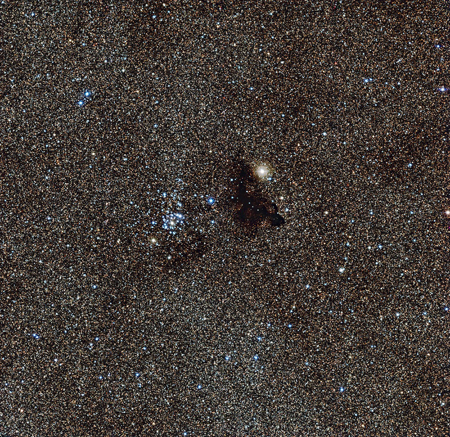 The bright star cluster NGC 6520 and the strangely shaped dark c