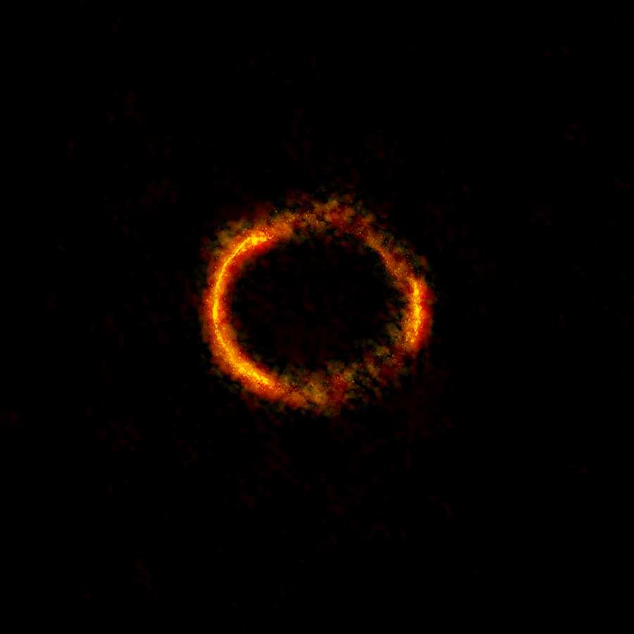 A região central alaranjada e brilhante do anel (a observação do ALMA com maior resolução até hoje) revela a poeira resplandescente nesta galáxia distante. As regiões de menor resolução que circundam o anel traçam a radiação milimétrica emitida por dióxido de carbono e por moléculas de água. Crédito: ALMA (NRAO/ESO/NAOJ); B. Saxton NRAO/AUI/NSF