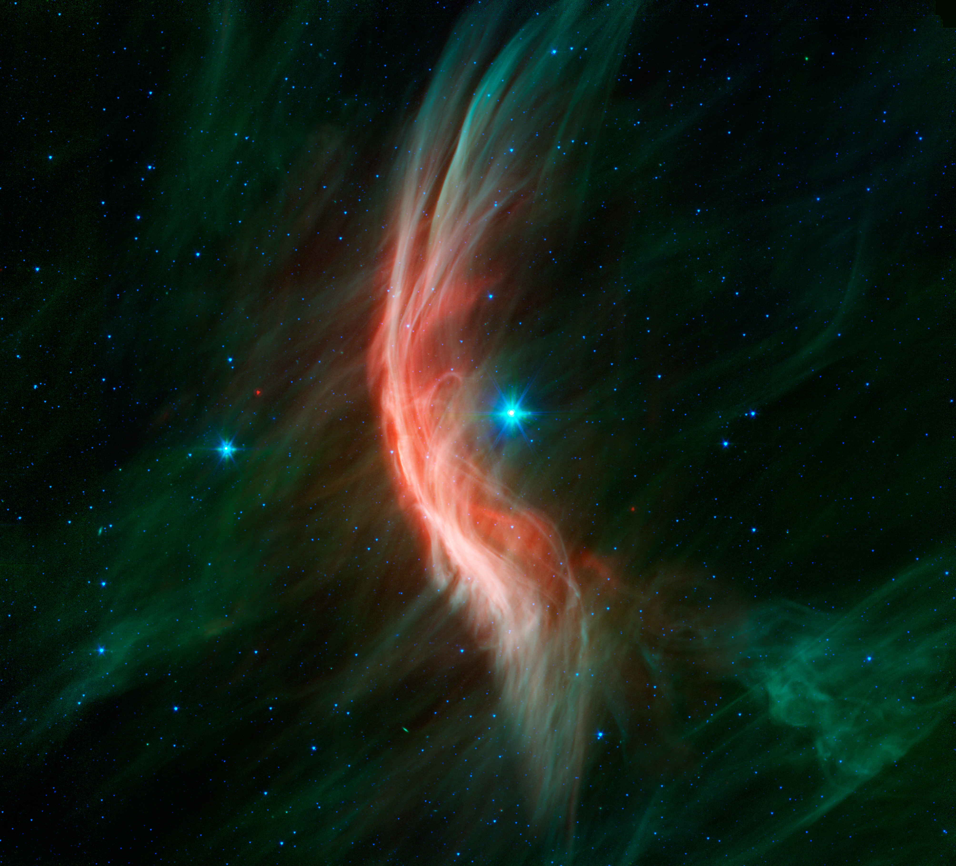 The giant star Zeta Ophiuchi is having a "shocking" effect on the surrounding dust clouds in this infrared image from NASAs Spitzer Space Telescope. Stellar winds flowing out from this fast-moving star are making ripples in the dust as it approaches, crea