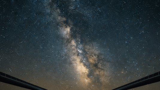 Os braços de 4 quilômetros do detector LIGO em Hanford, Washington, se estendem sob um manto estelar, uma maravilha da engenharia projetada para 'ouvir' as mais tênues ondulações no espaço-tempo.